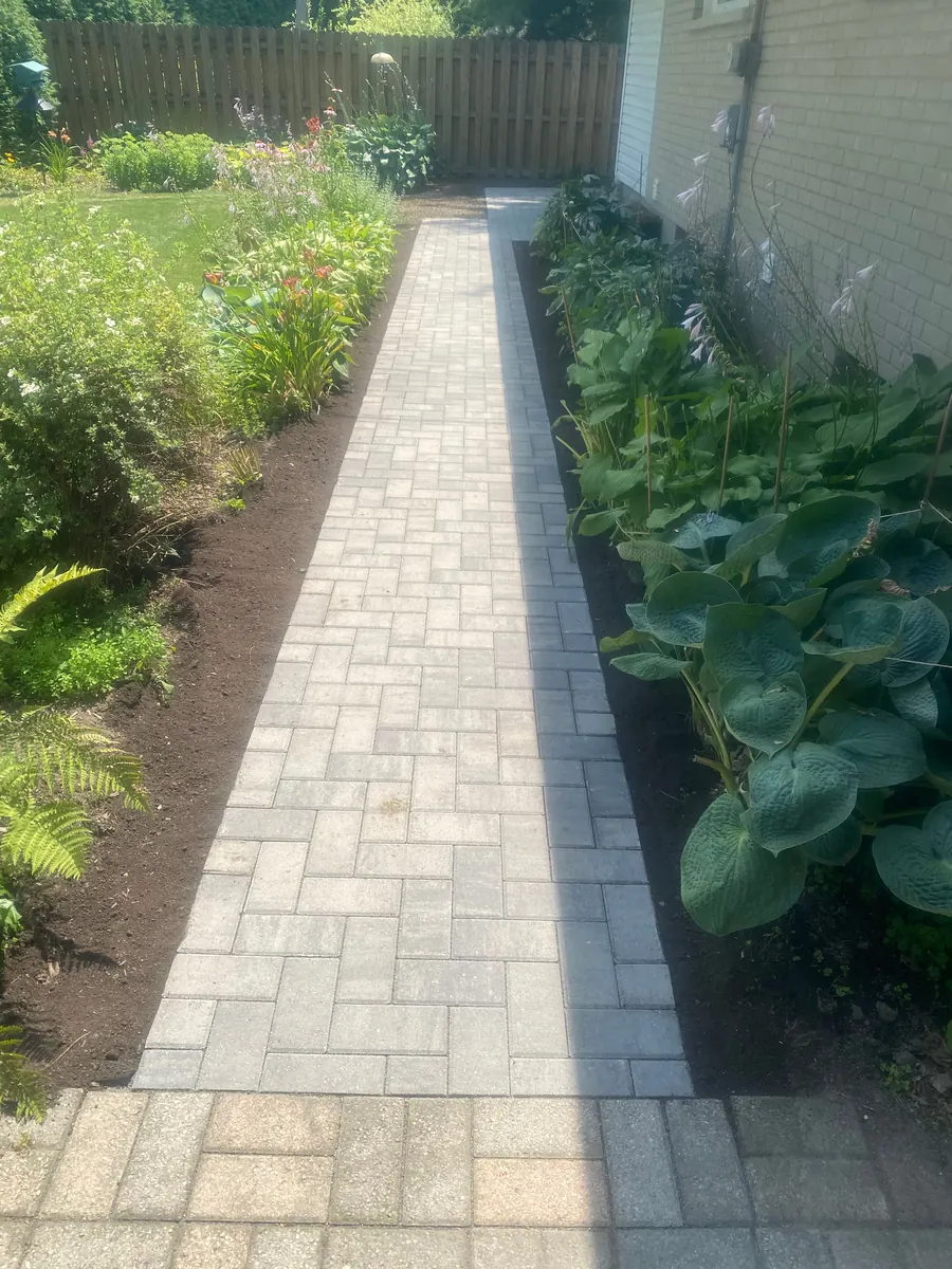 Paver walkway running between planted garden beds