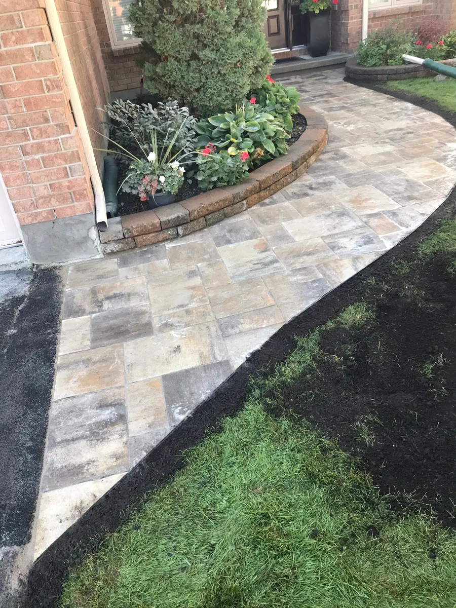 Narrow paver walkway threading between garden beds